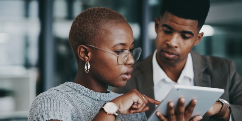 Two people looking at a tablet