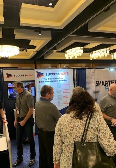 Attendees mingling and chatting with the Successware team in our booth at the SGI trade show.