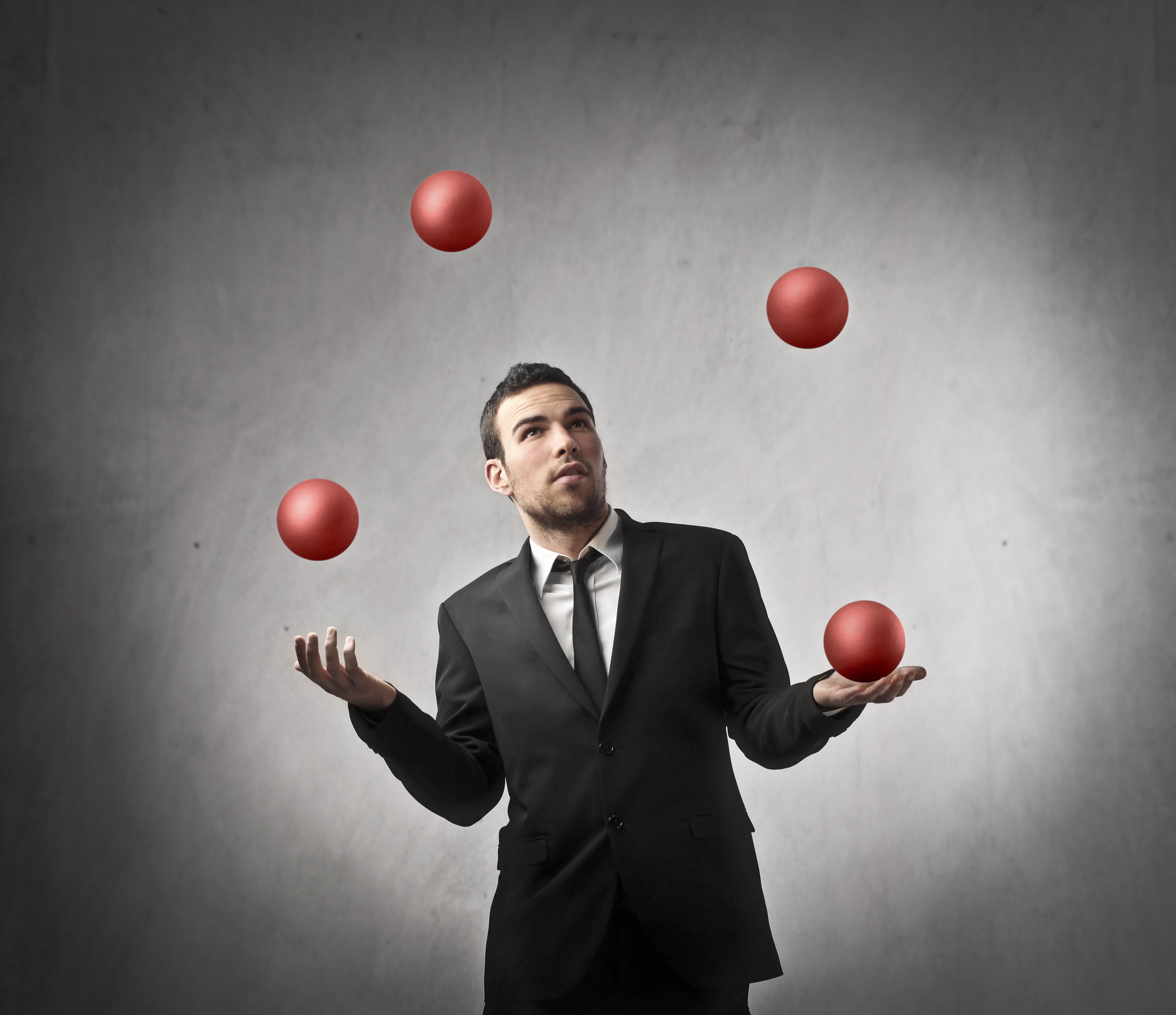 Skillful Businessman juggling red balls