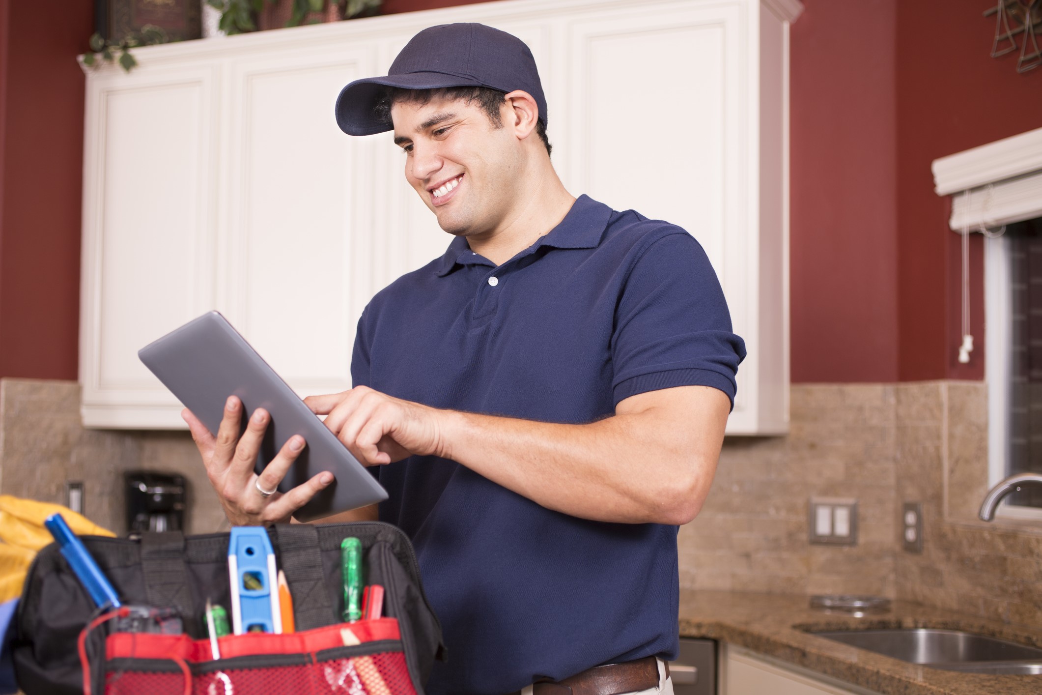 Repairman working inside customer's home with iPad.