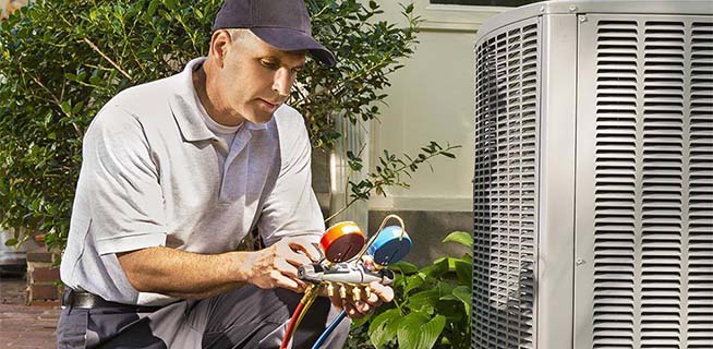 HVAC technician working on an AC unit outside